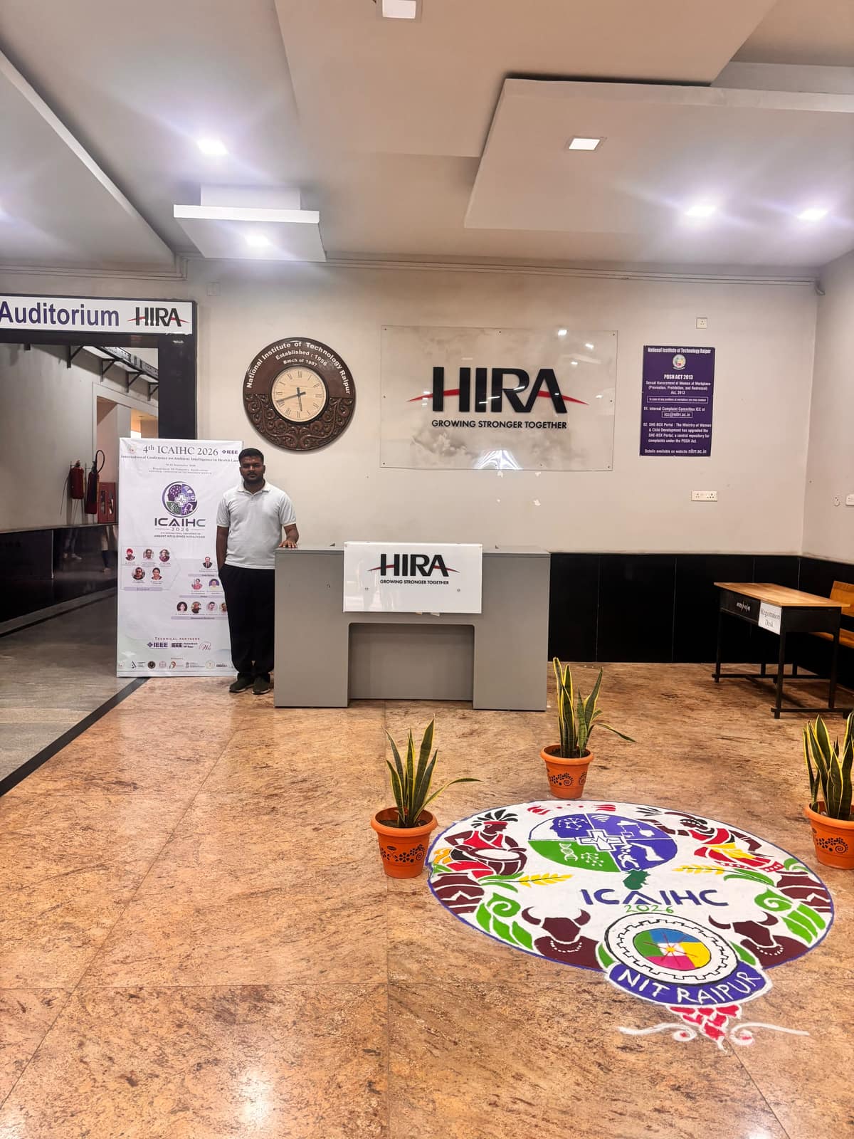 Aman Chandra H at ICAIHC 2026, NIT Raipur, beside the conference rangoli